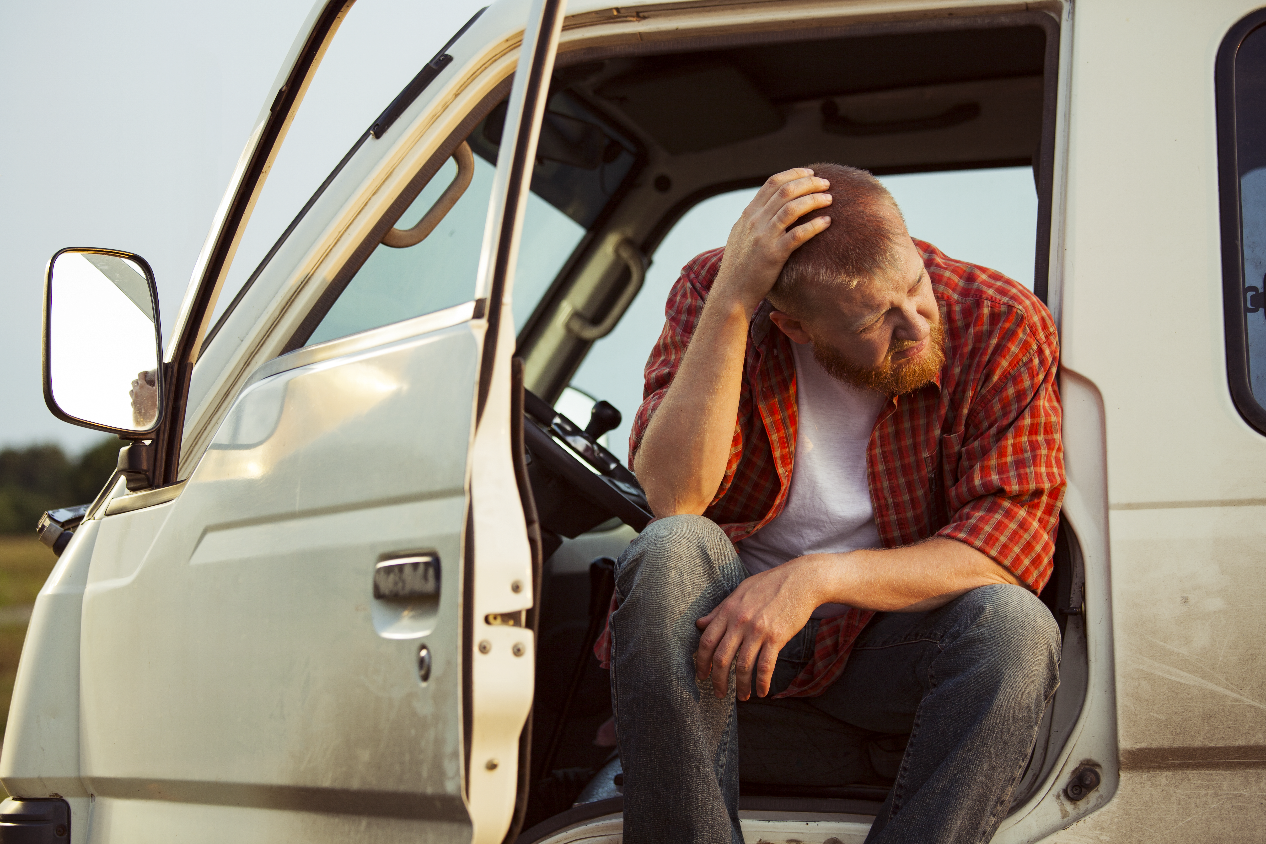 Man sitting in truck scratching his head in confusion