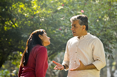 IMAGE: couple arguing outdoors, man appears frustrated.